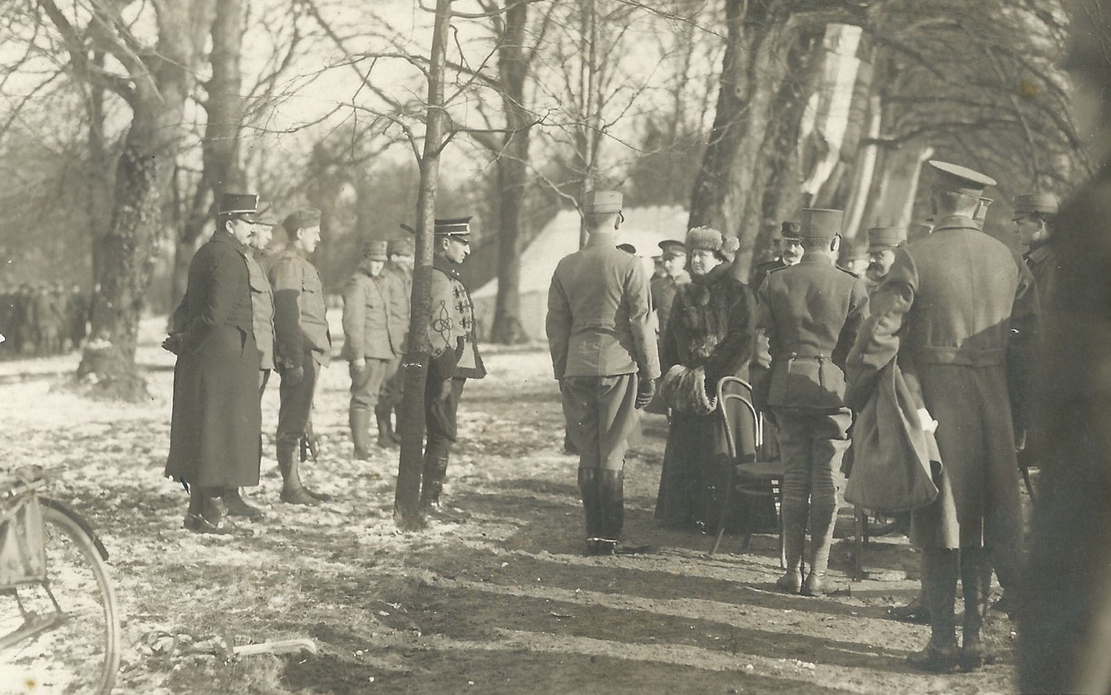 Koningin op land tussen militairen sommigen dragen hun schaatsen in de hand