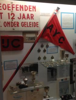 Vlag met stok in vitrine van het Eerste Friese Schaatsmuseum